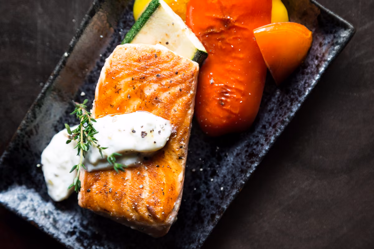 Gebratener Fisch mit Gemüse auf einer Schieferplatte