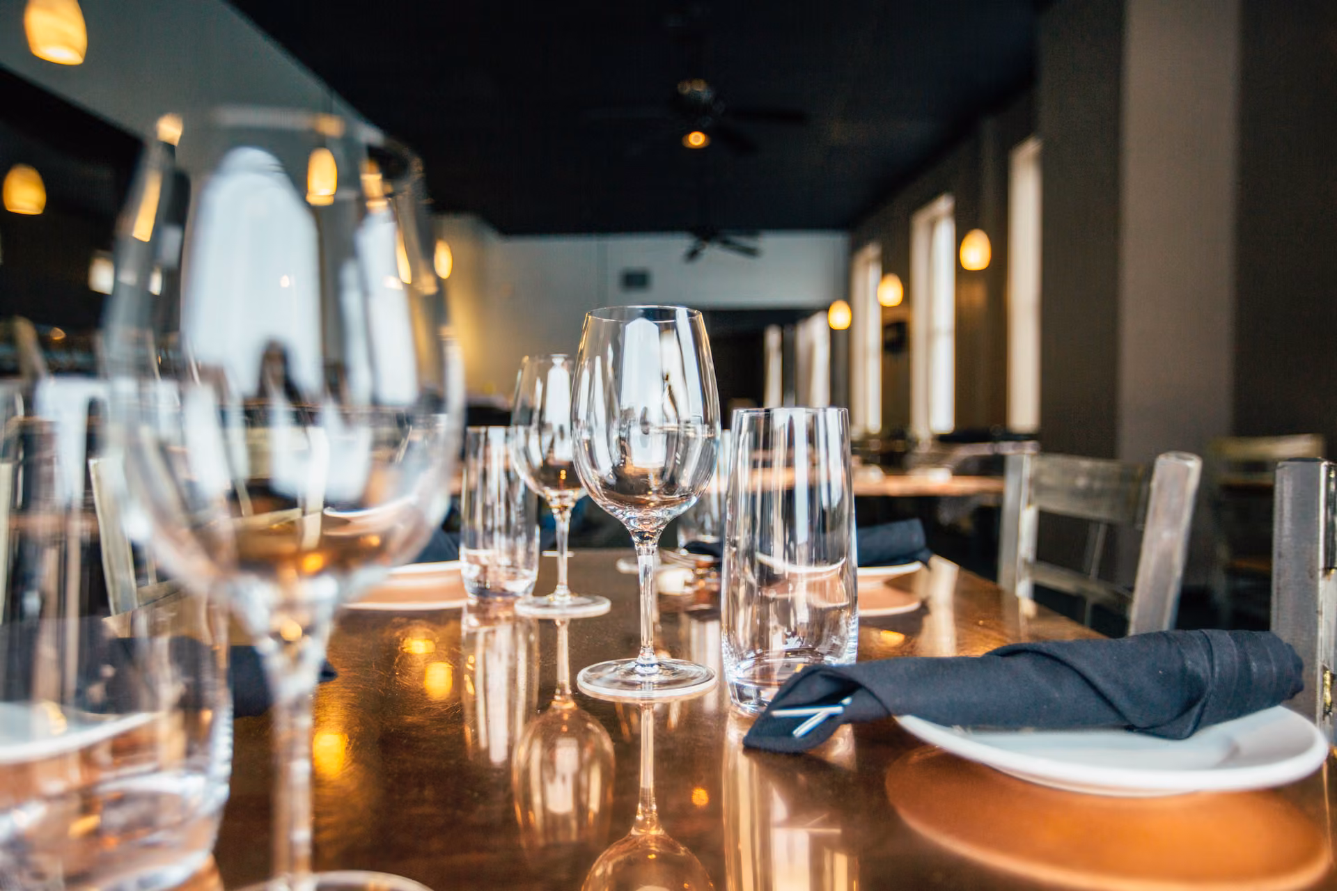 Gedeckter Tisch mit Weingläsern im Speisesaal am Abend